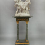 19th century Carrara Marble Figural group of Drunken Silenus seated on a tall and thin green and gold table.